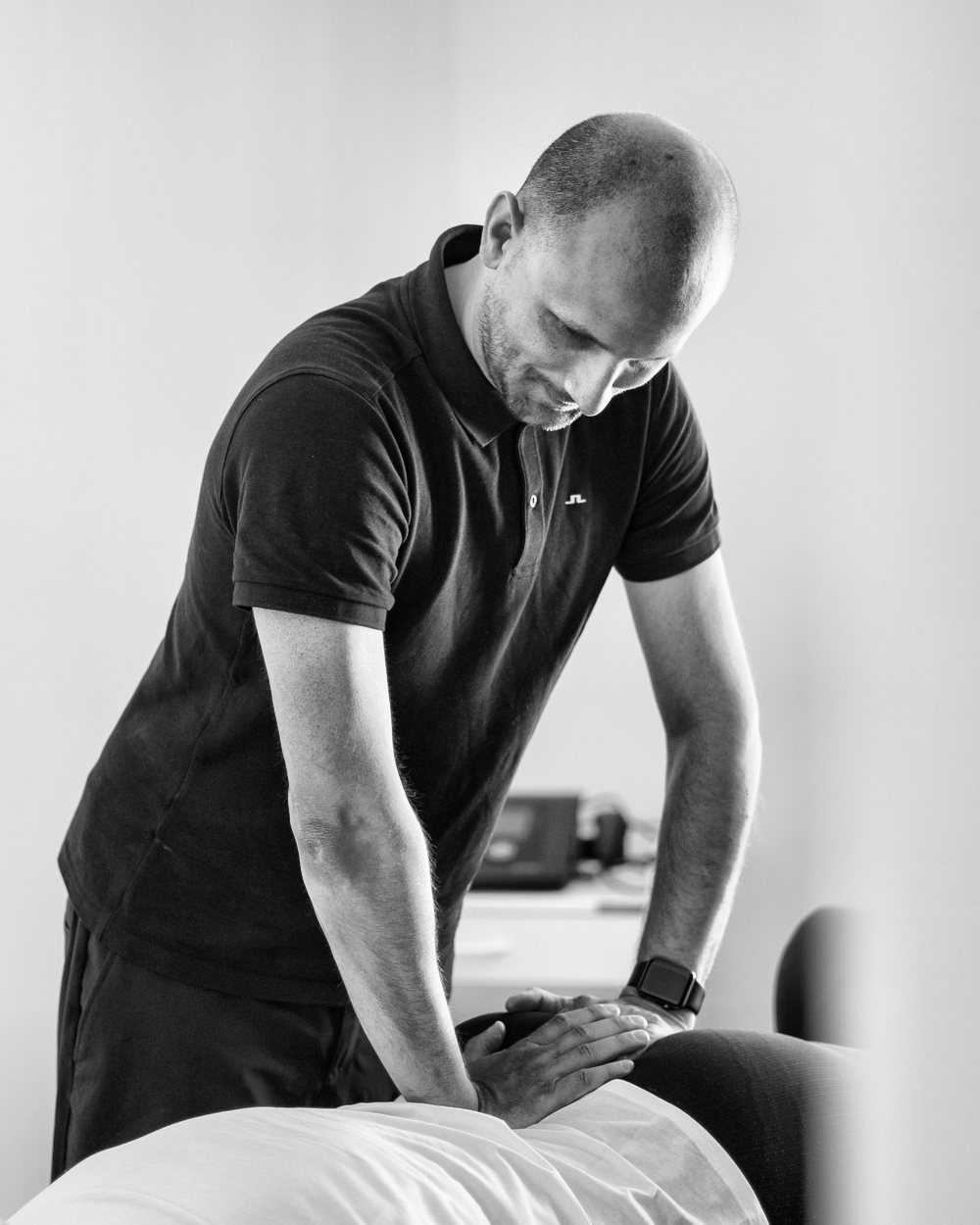 Physiotherapeut Thomas Schmidt behandelt eine Patientin auf der Therapieliege